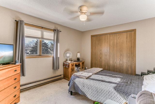 carpeted bedroom featuring ceiling fan, a textured ceiling, baseboard heating, and a closet