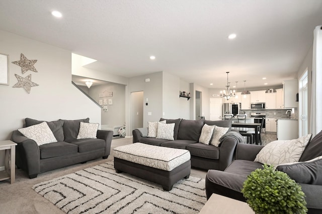 living area featuring light carpet, a chandelier, and recessed lighting