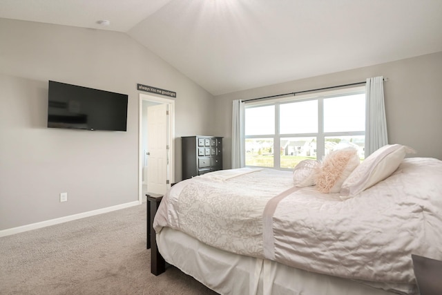 carpeted bedroom with lofted ceiling and baseboards