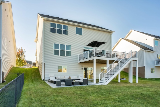 back of house with stairs, fence, a lawn, and an outdoor hangout area