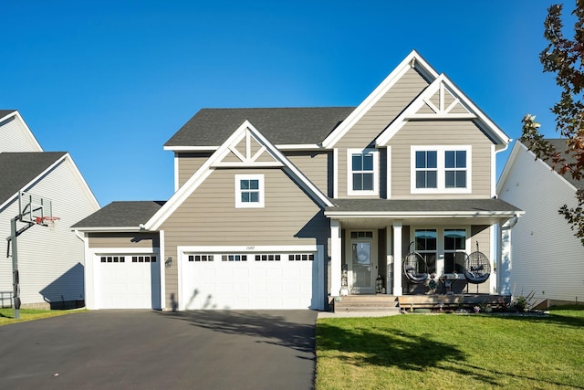 view of front of home with driveway, covered porch, roof with shingles, and a front yard