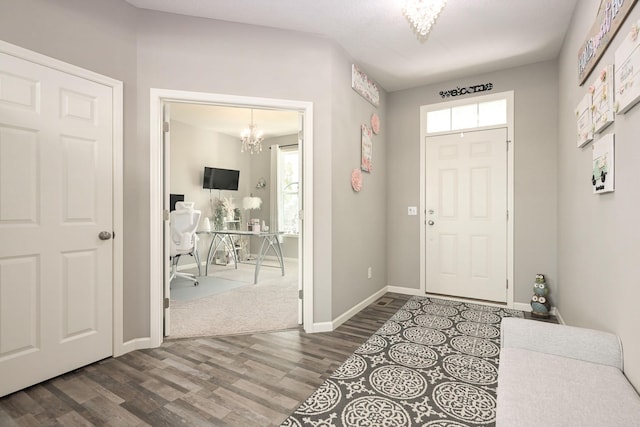 foyer featuring a healthy amount of sunlight, wood finished floors, and a notable chandelier