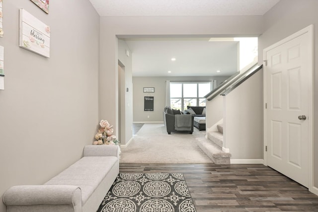 interior space featuring recessed lighting, dark wood-style flooring, baseboards, and stairs