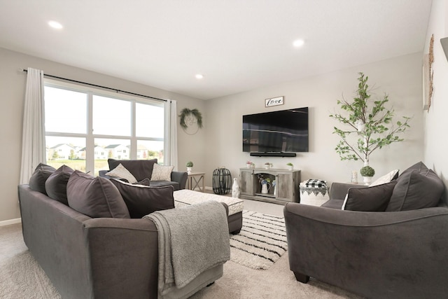 living room with recessed lighting, light colored carpet, and baseboards