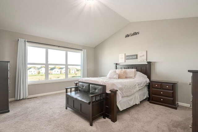 bedroom with lofted ceiling, baseboards, and light colored carpet