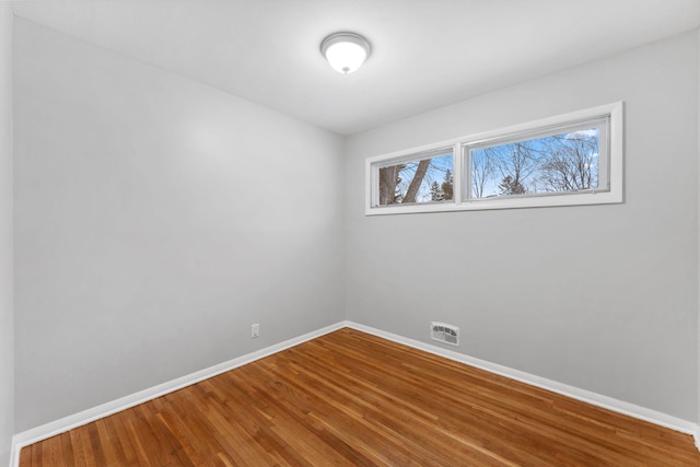 unfurnished room with hardwood / wood-style flooring