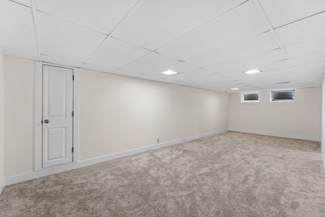 basement with a drop ceiling and carpet flooring