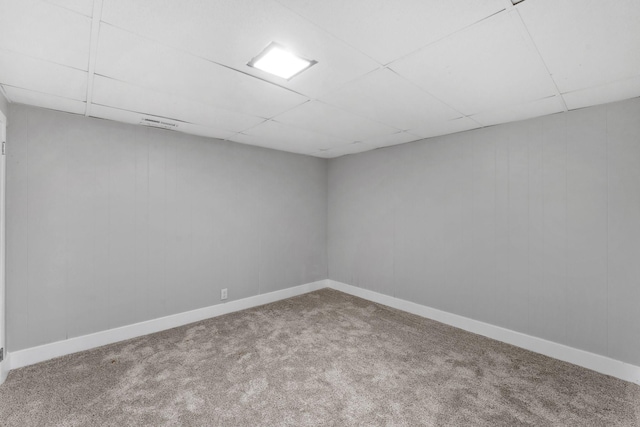 empty room with carpet floors and a paneled ceiling