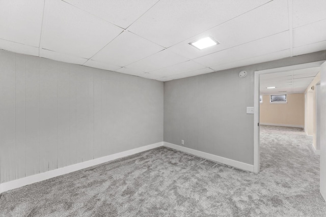 carpeted empty room with a paneled ceiling