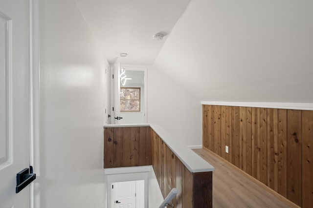 interior space featuring vaulted ceiling, hardwood / wood-style flooring, and wooden walls