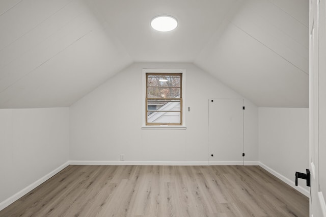 bonus room with lofted ceiling and light wood-type flooring