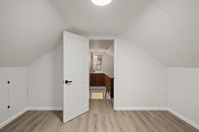 additional living space featuring lofted ceiling and light hardwood / wood-style flooring