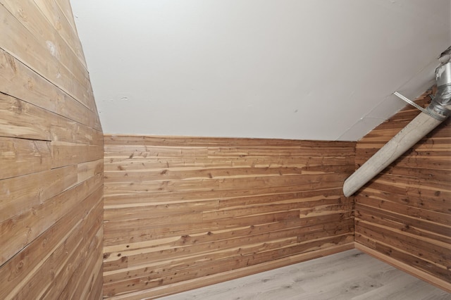 interior details featuring wood-type flooring and wooden walls