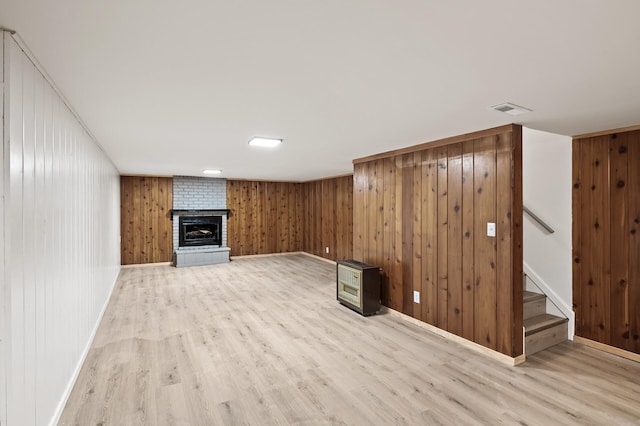 basement featuring light hardwood / wood-style floors and wooden walls