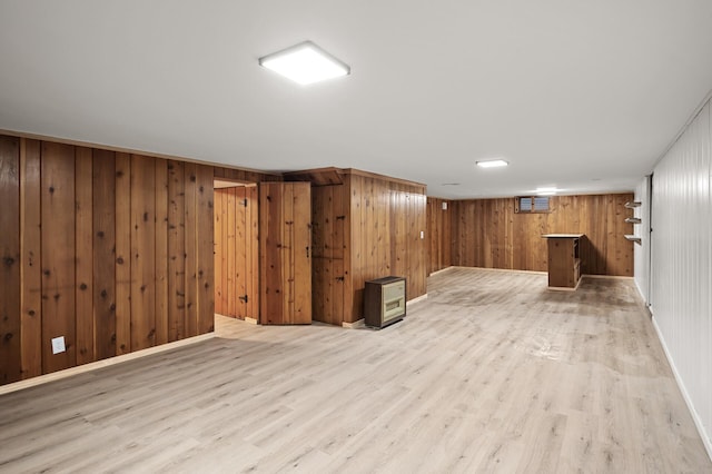 basement featuring light hardwood / wood-style flooring and wood walls