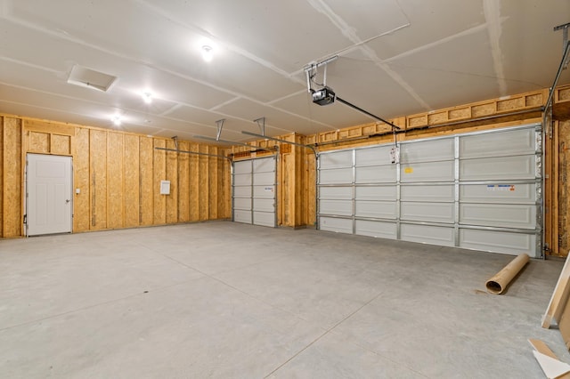 garage featuring a garage door opener and wood walls