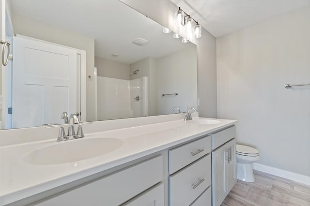 bathroom with toilet, a textured ceiling, a shower, wood-type flooring, and vanity