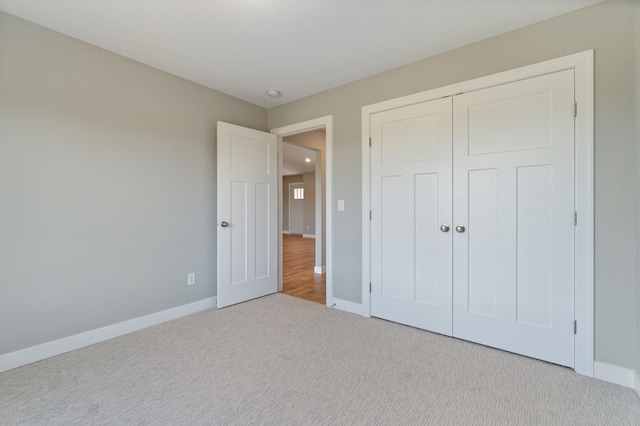 unfurnished bedroom featuring a closet and light carpet