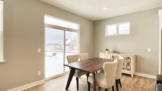 dining space featuring a textured ceiling and light hardwood / wood-style floors