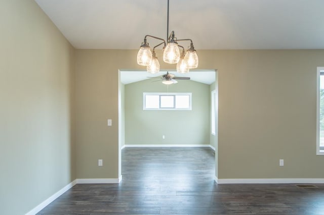 unfurnished dining area with ceiling fan with notable chandelier, dark hardwood / wood-style flooring, and lofted ceiling