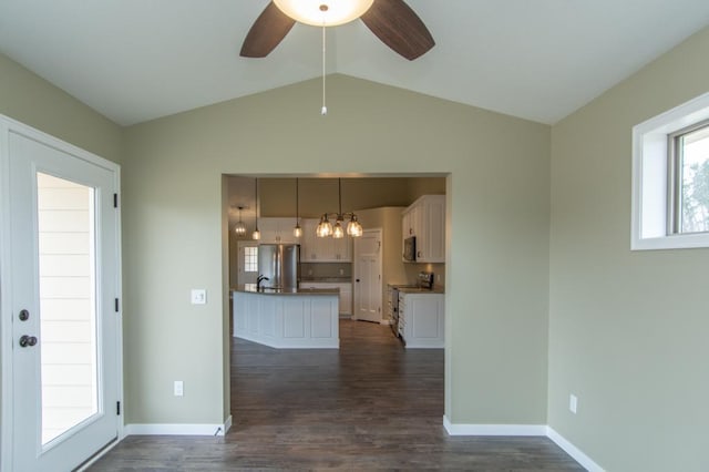 interior space with white cabinetry, ceiling fan, range, hanging light fixtures, and stainless steel fridge