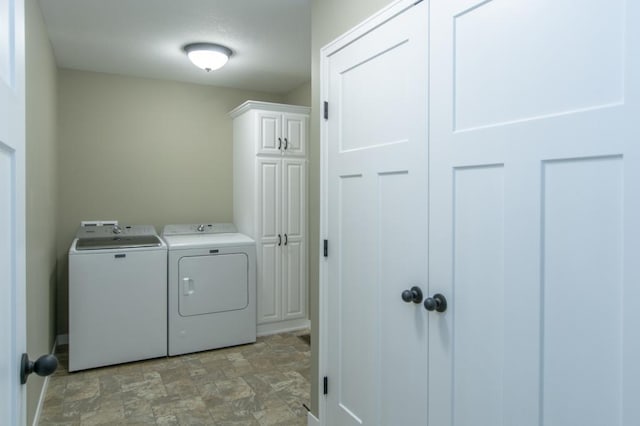 laundry area featuring washer and dryer and cabinets