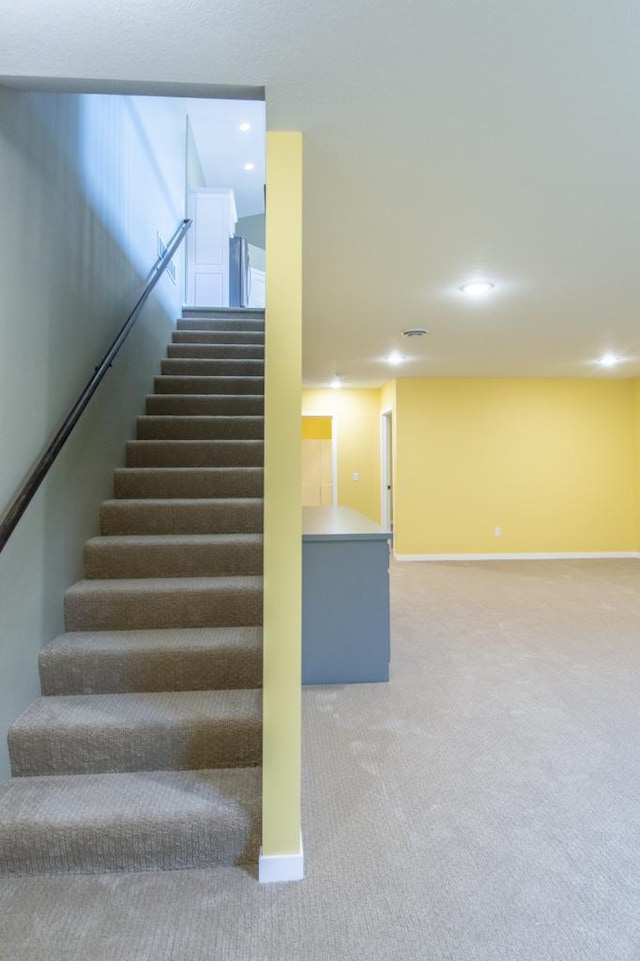 staircase featuring carpet flooring