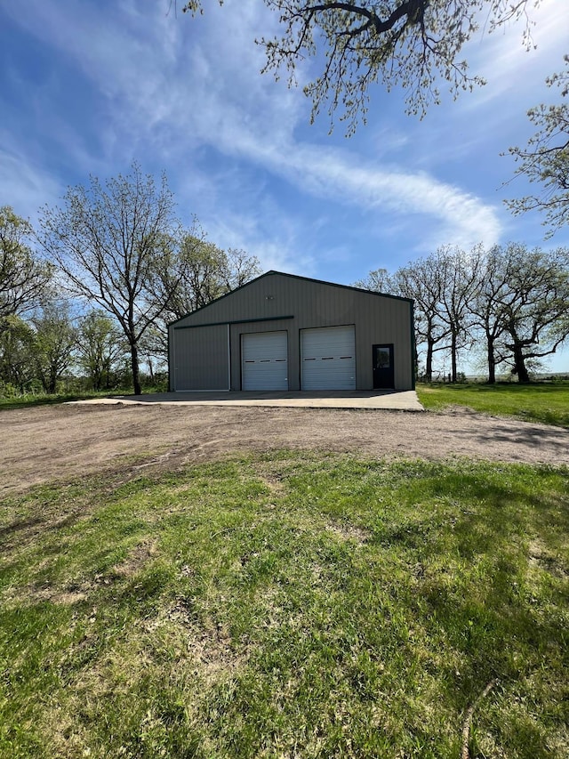 detached garage featuring dirt driveway