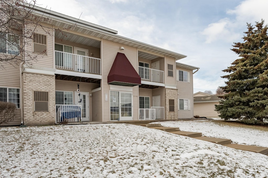 view of snow covered rear of property