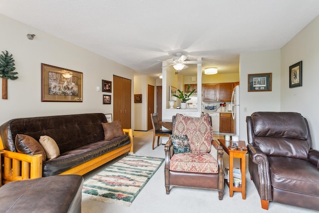 carpeted living room with a textured ceiling and ceiling fan