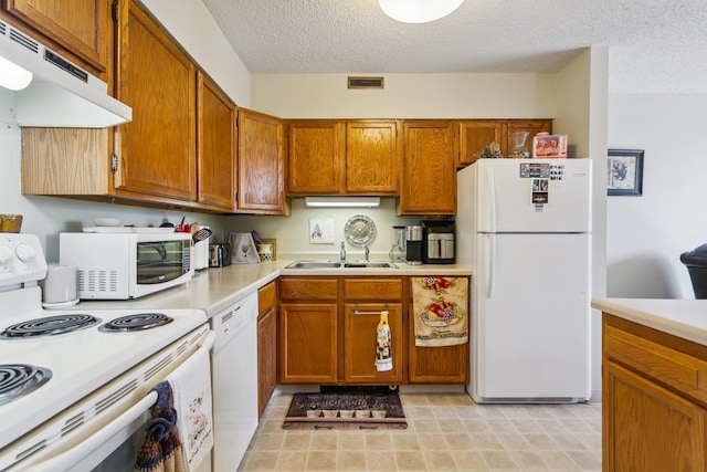 kitchen with sink, white appliances, and a textured ceiling