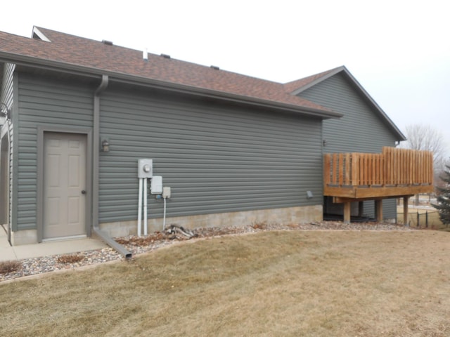 view of home's exterior featuring a deck and a lawn