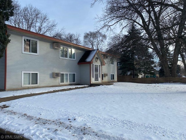 view of snow covered exterior with a wall unit AC