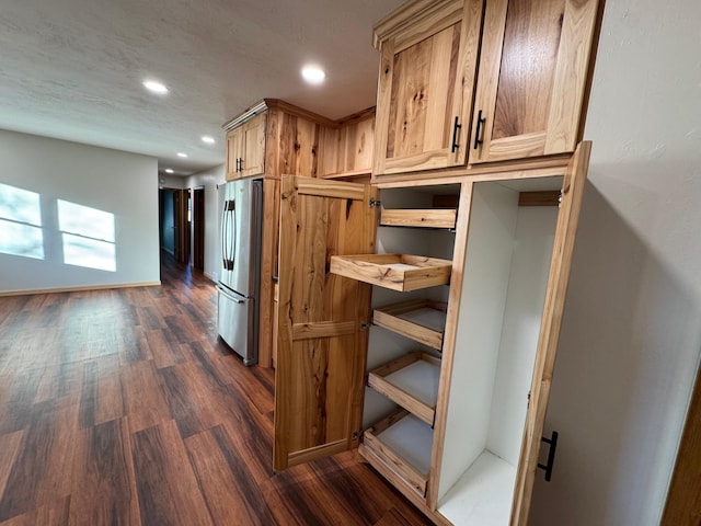 interior space with dark wood-type flooring and stainless steel refrigerator