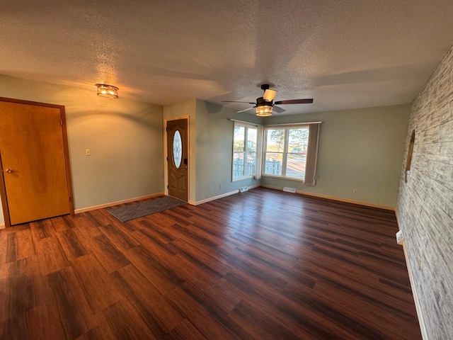 interior space featuring dark wood-type flooring, a textured ceiling, and ceiling fan