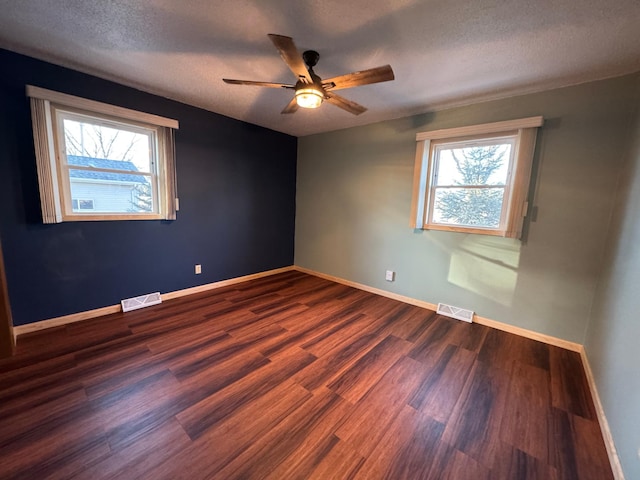 spare room featuring ceiling fan, dark hardwood / wood-style floors, and a textured ceiling