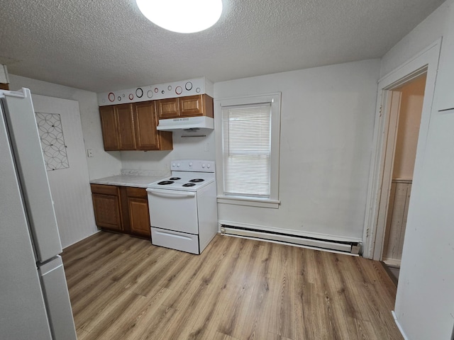 kitchen with white appliances, baseboard heating, light hardwood / wood-style floors, and a textured ceiling