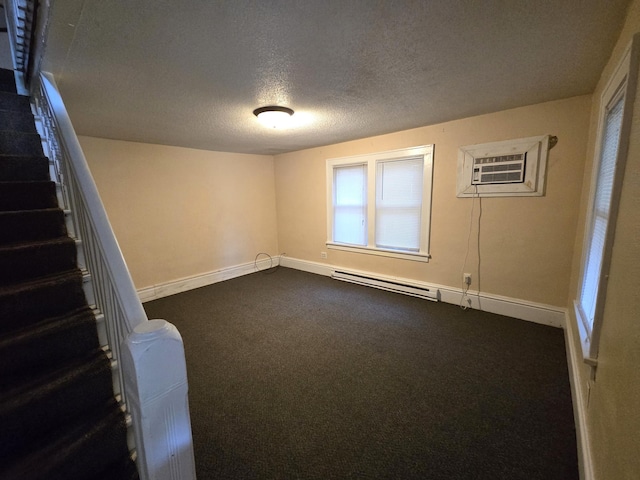 basement featuring a wall mounted AC, a baseboard radiator, a textured ceiling, and carpet