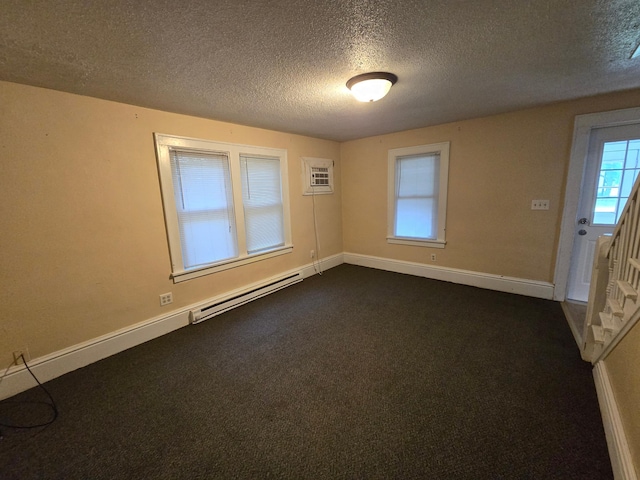 unfurnished room featuring a textured ceiling, baseboard heating, and a wall mounted AC