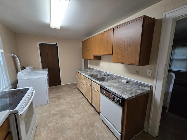 kitchen with washing machine and dryer, white appliances, and sink