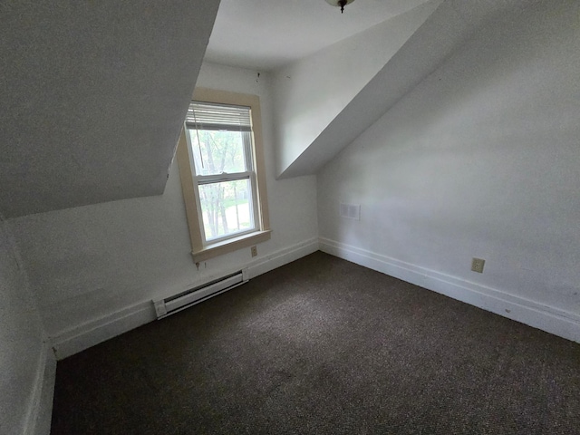 additional living space featuring a baseboard radiator, dark carpet, and lofted ceiling