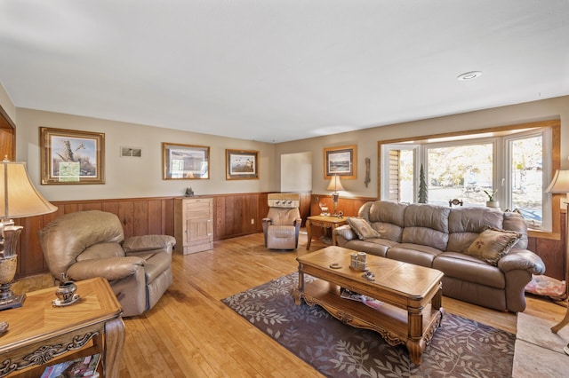 living area featuring wainscoting, light wood-style floors, and wooden walls