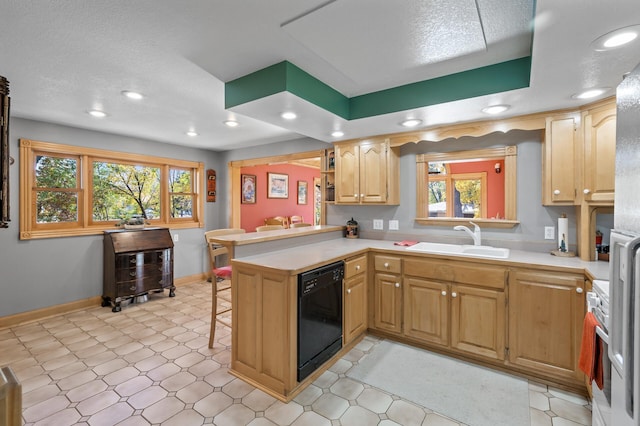 kitchen featuring dishwasher, a sink, a peninsula, light countertops, and recessed lighting