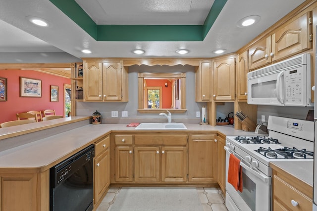 kitchen featuring white appliances, a sink, light countertops, a tray ceiling, and recessed lighting
