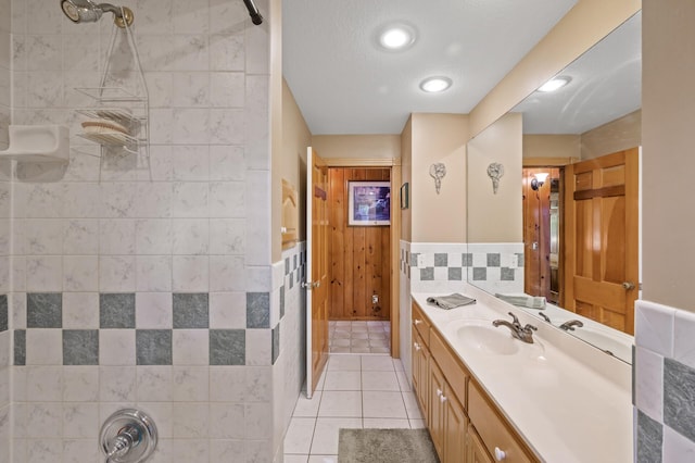 full bath featuring vanity, a shower, tile patterned flooring, wainscoting, and recessed lighting