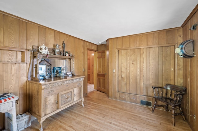 sitting room featuring wooden walls and light wood-style flooring