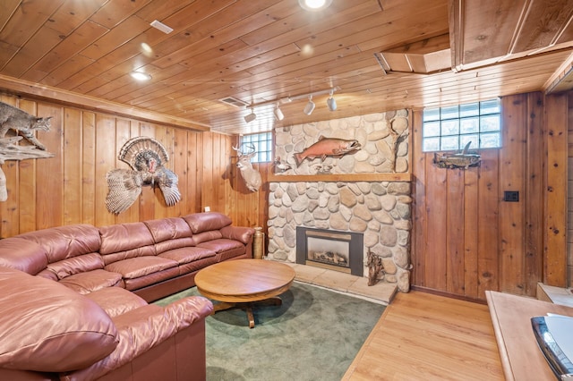 living room with wood ceiling, plenty of natural light, wood finished floors, wooden walls, and a fireplace