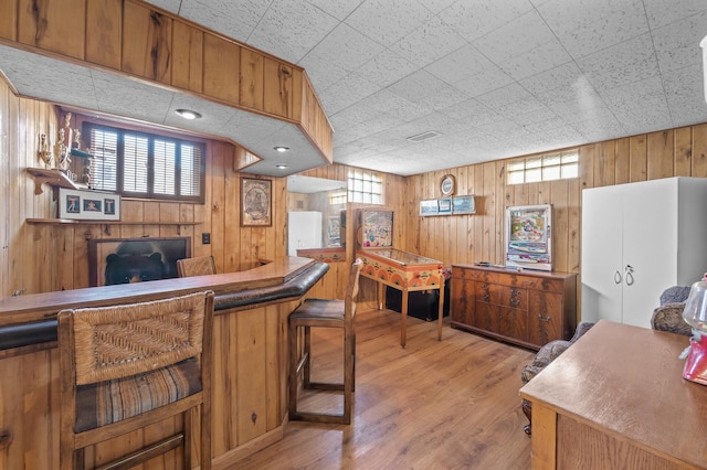 indoor dry bar with wooden walls and light wood finished floors