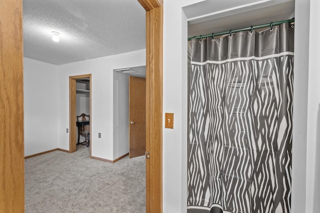 full bath with baseboards and a textured ceiling