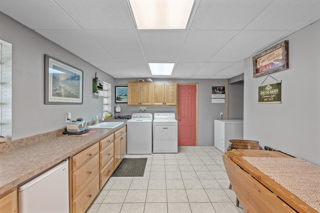 clothes washing area with washer and clothes dryer, cabinet space, and light tile patterned floors
